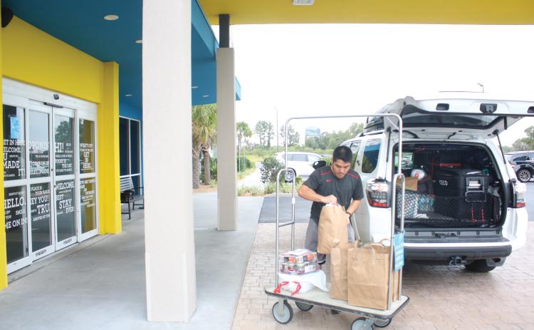 Long Vu, from Tampa, unpacks his vehicle at the Tru by Hilton hotel in Lake City in September. Columbia County’s Tourism Development Council said the county had collected over $2 million in bed taxes for the first time ever. (FILE)