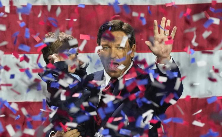 Incumbent Florida Republican Gov. Ron DeSantis holds his son Mason as he celebrates winning reelection, at an election night party Tuesday in Tampa. (REBECCA BLACKWELL/Associated Press)
