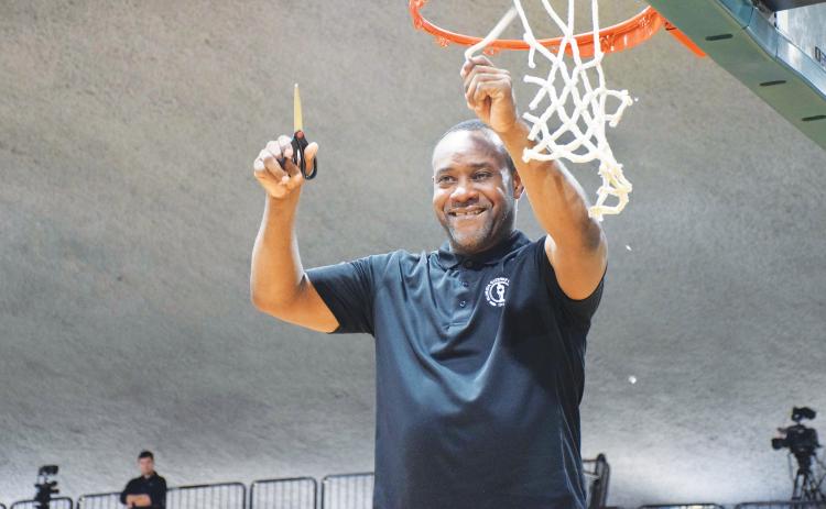 FGC head coach Charles Ruise cuts down a piece of the net after the Timberwolves defeated Pasco-Hernando State College to win the Region 8 championship on Feb. 26 at the Howard Center. (COURTESY)