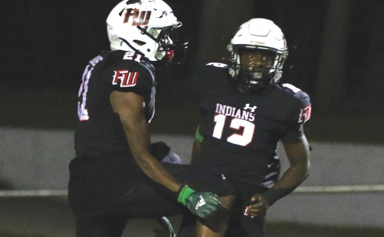 Fort White running back Najeeb Smith (12) celebrates with teammate Kamarion Griffin after scoring a touchdown against Santa Fe last Friday. (MORGAN MCMULLEN/Lake City Reporter)