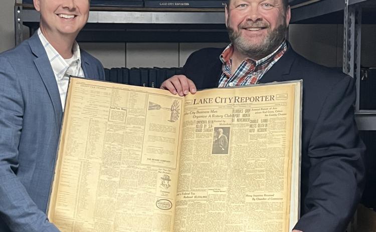 Jay Swisher, Columbia County Clerk of Courts and 2022-23 Rotary Club of Lake City President, and Todd Wilson, Publisher of the Lake City Reporter and Rotarian, hold up the Nov. 17, 1922, edition of the Reporter, which includes the story on the formation of the Rotary Club 100 years ago today. (JAMIE WACHTER/Lake City Reporter)