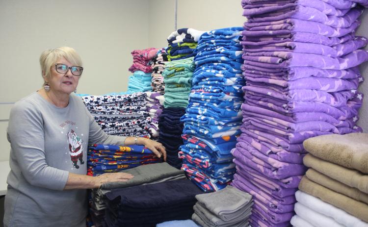 Meally Jenkins, the founder and director of the Christmas Dream Machine, looks over the towels that have been donated to the organization. (TONY BRITT/Lake City Reporter)