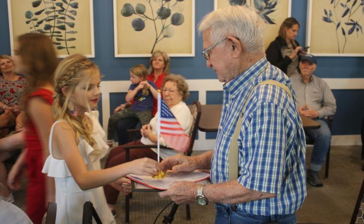 Jocelyn Jenkins (left), 12, presents John Cruise, an Army veteran, with a desk flag during a veterans recognition award ceremony at The Canopy. (TONY BRITT/Lake City Reporter)