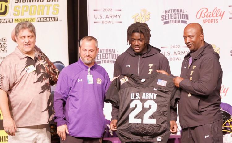 Columbia linebacker Jaden Robinson (center right) was presented with a U.S. Army All-American by U.S. Army Bowl Director Marc Boldurian (left) during a ceremony at Columbia High School on Thursday. The two are pictured with principal Trey Hosford (center left) and head coach Demetric Jackson (right). (JAMIE WACHTER/Lake City Reporter)