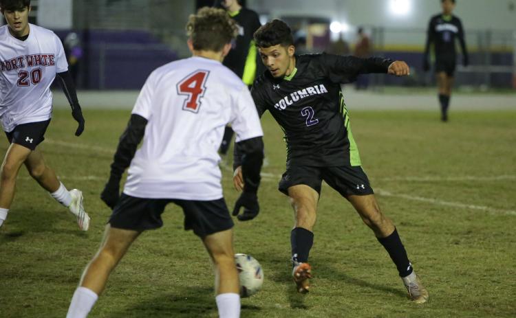 Columbia’s Jason Caballero dribbles up the field against Fort White’s Gavin Heaton on Monday night. (BRENT KUYKENDALL/Lake City Reporter)