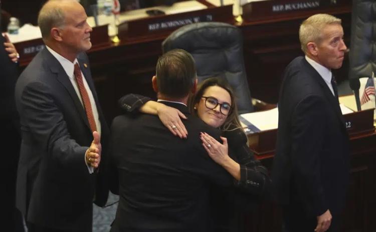 Rep. Bob Rommel (R-Naples) is hugged by Rep. Josie Tomkow (R-Polk City) after his SB 2-A Property Insurance bill he co-sponsored passed Wednesday in the House of Representatives in Tallahassee. At left is Rep. Bobby Payne (R-Palatka); at right is House Speaker Paul Renner (R-Palm Coast). (PHIL SEARS/Associated Press)
