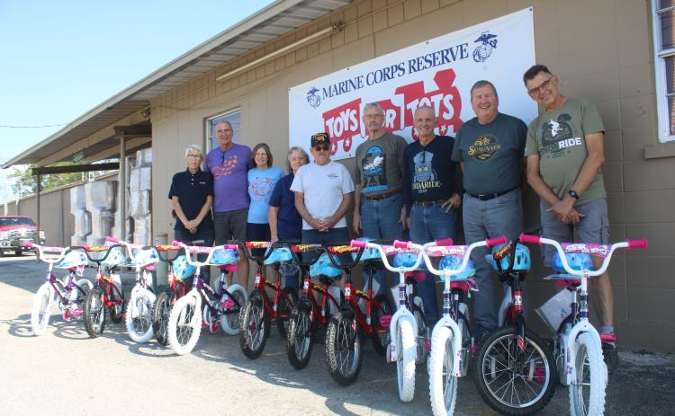 Inga Dwyer (from left), Toys for Tots Coordinator stands with Suwannee Bicycle Association members Mick Shea, Sharon Shea, Nancy Kelley, Mike Kelley, Michael Toffolo, Dale Nanny, George Litteral and Mark Wiencek after they donated 12 bikes to the local Toys for Tots program. (TONY BRITT/Lake City Reporter)