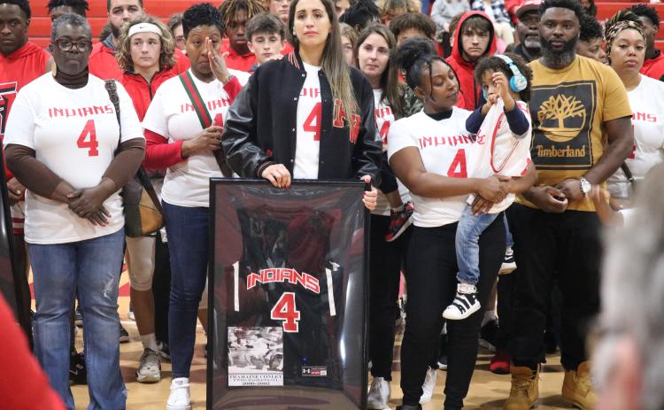 Samira Conley, the wife of Tramaine Conley, holds back tears after being presented with his Fort White jersey prior to Thursday’s game against Bell. (JORDAN KROEGER/Lake City Reporter)