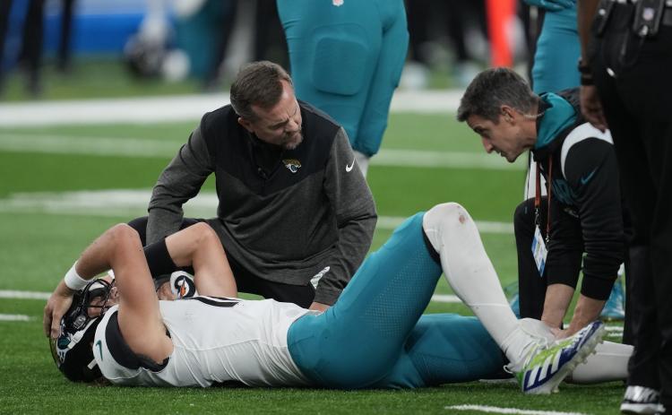 Jacksonville Jaguars quarterback Trevor Lawrence is examined after a sack during Sunday's game against the Detroit Lions in Detroit. (PAUL SANCYA/Associated Press)