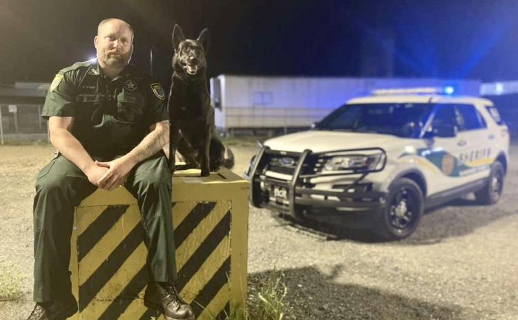 Suwannee County Sheriff’s Office Cpl. Justin Stout sits with K-9 Officer Loki. Loki passed away yesterday morning after being diagnosed with cancer. (COURTESY)