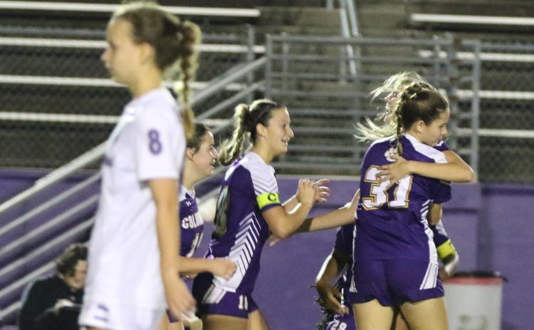 Columbia’s Mia Brasel is embraced by teammates Sydney Rivas (31) and Skyler Ziegaus (left) after her goal as Gainesville’s Emily Brown (8) walks away Wednesday night. (MORGAN MCMULLEN/Lake City Reporter)