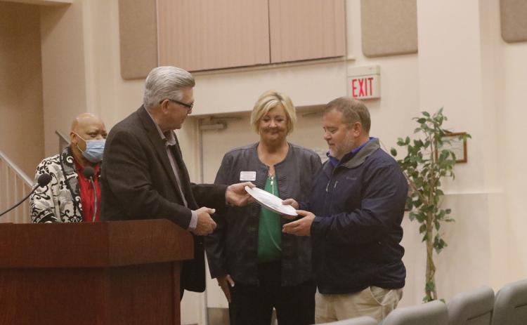 David Boozer (left), the Florida Gateway Food Bank Manager, presents a ceremonial plate to Eastside Elementary Principal Roger Little as Catholic Charities Regional Director Suzanne Edwards looks on. (JAMIE WACHTER/Lake City Reporter)