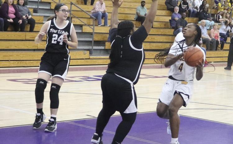 Columbia’s Eriel Baker goes for a layup attempt as Fort White’s N’Coreyia Atkins gets in her way. (MORGAN MCMULLEN/Lake City Reporter)