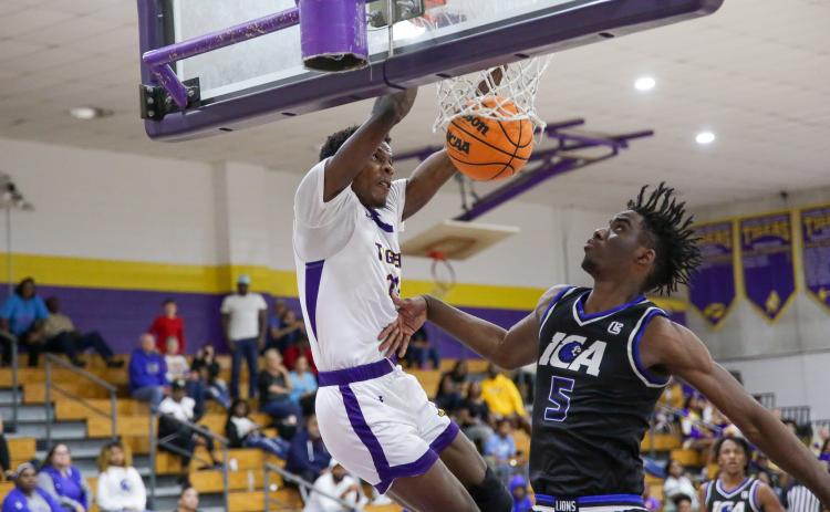 Columbia forward Seth Stockton dunks in front of Impact Christian Academy forward Jordan Mikell on Thursday night. (BRENT KUYKENDALL/Lake City Reporter)