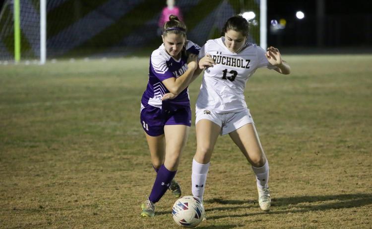 Columbia’s Sydney Rivas (left) battles for control of the ball with Buchholz’s Zoe Torres during Tuesday night’s game at Tiger Stadium. Torres scored a goal for her side in the 4-1 CHS loss. (BRENT KUYKENDALL/Special to the Reporter)
