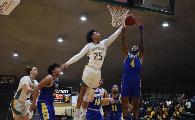 FGC forward Antewan Webber defends a shot from Trinity Baptist forward Marc Maisonnet on Monday night. (COURTESY OF FGC)
