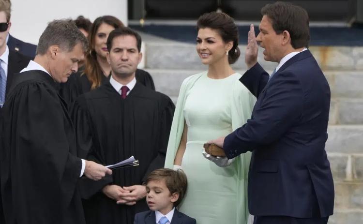 Florida Gov. Ron DeSantis, right, is sworn by Florida Supreme Court Chief Justice Carlos Muniz, left, to begin his second term during an inauguration ceremony outside the Old Capitol on Tuesday in Tallahassee. Looking on is DeSantis’ wife Casey, second from right, and their son Mason. (LYNNE SLADKY/Associated Press)
