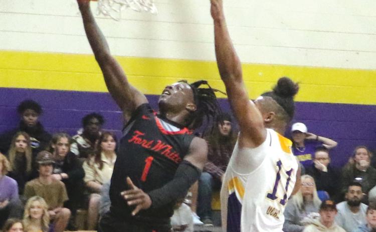 Fort White guard Najeeb Smith make a layup against Union County guard Thomas Williams on Friday. (MORGAN MCMULLEN/Lake City Reporter)