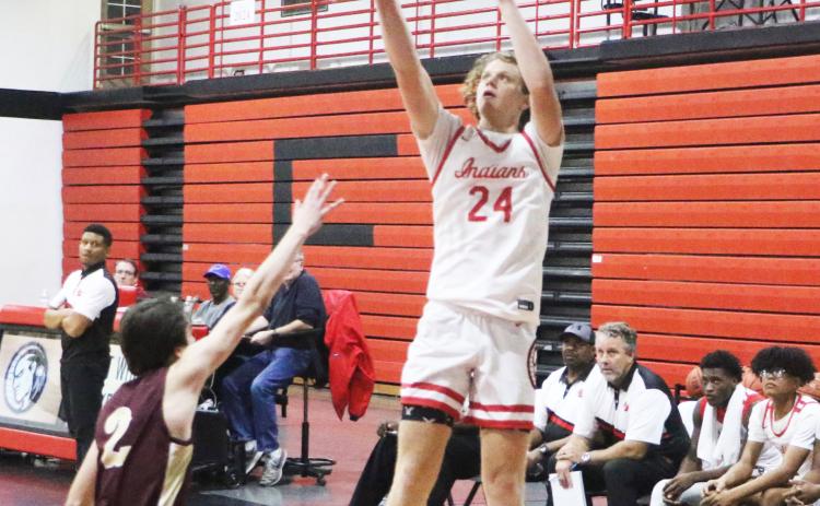 Fort White forward Brandon DeMartino shoots over Oak Hall’s Ryan McKinny on Thursday night. (MORGAN MCMULLEN/Lake City Reporter)