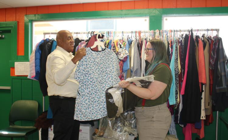 Philip Mobley (left), NorthStar Family Resource Center manager, hangs clothing at the facility Monday after with help from Christen Lancaster, NorthStar Community Center Community Research Coordinator. (TONY BRITT/Lake City Reporter)