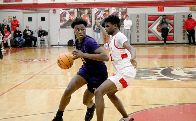 Columbia forward Ty’jahn Wright drives to the basket while defended by Santa Fe forward Antonio Hall on Friday night. (JORDAN KROEGER/Lake City Reporter)