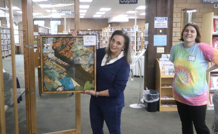 Gayle Rogers shows off a textile art work of an alligator that will be on display at the Columbia County Public Libary’s Main Branch as part of the Lady of the Lake Quilt Guild’s display through Feb. 21. (MORGAN MCMULLEN/Lake City Reporter)