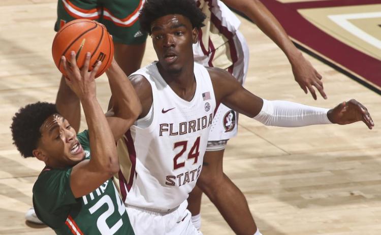 Miami guard Nijel Pack (24) gets a rebound as Florida State center Naheem McLeod (24) looks on during Tuesday's game in Tallahassee. (PHIL SEARS/Associated Press)