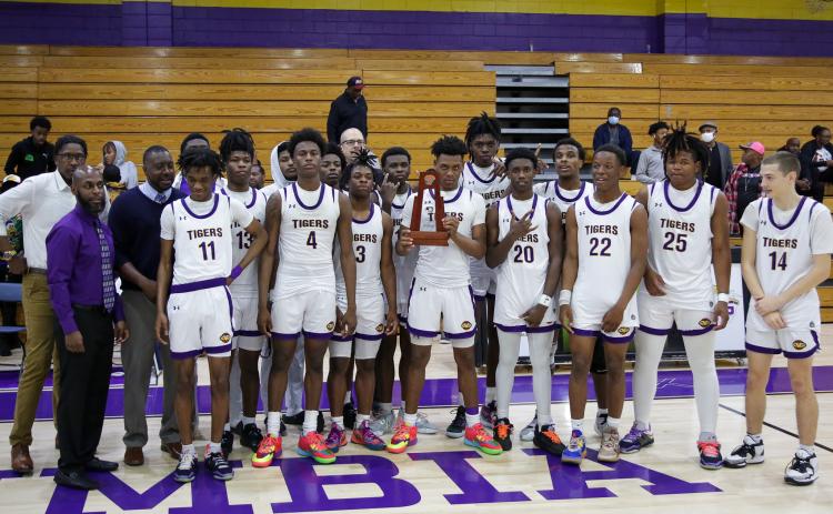 Columbia’s basketball team poses with the District 2-5A championship trophy after defeating Rickards 68-38 on Friday night. (BRENT KUYKENDALL/Lake City Reporter)
