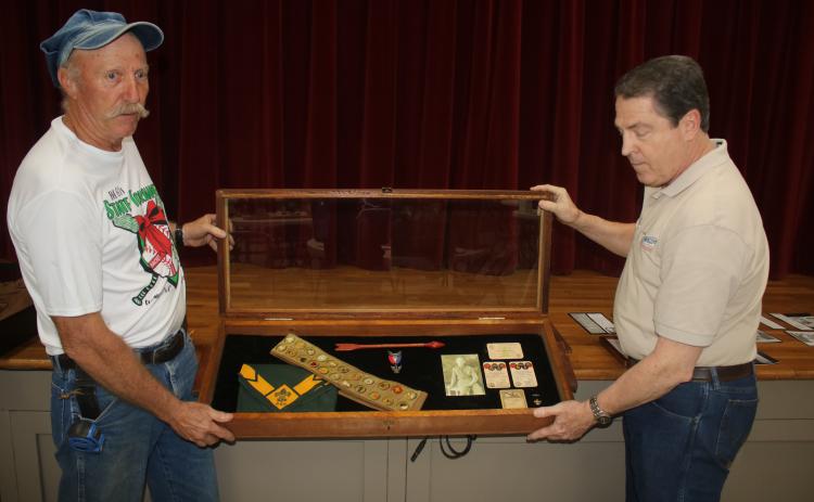 Jay Fraser (from left), local scouting organization representative and Darrel Mathis, Boy Scout Troop 85 Committee Chair, set up a display in the First Presbyterian Church Fellowship Hall that displays scouting memorabilia of Forrest Bradbury, the first Eagle Scout for the group from 1931. A reception will take place Sunday morning in the fellowship hall to celebrate 100 years of local scouting. (TONY BRITT/Lake City Reporter)