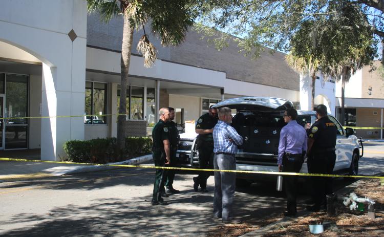 Law enforcement officers go through their latest updates on Tuesday morning at the mobile command post at the State of Florida Probation & Parole Services office. (TONY BRITT/Lake City Reporter)