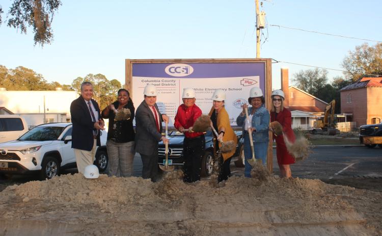 Columbia County Superintendent Lex Carswell (from left), Fort White Elementary Principal Syreeta Jackson-Lee, and school board members Hunter Peeler, Keith Hudson, Dana Brady-Giddens, Narrie Smith, and Cherie Hill take part in the ceremonial groundbreaking at Fort White Elementary Tuesday. (TONY BRITT/Lake City Reporter)