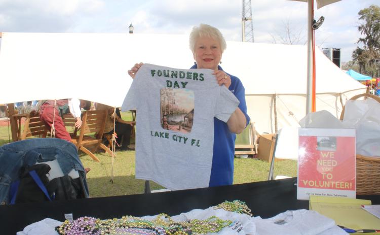 Ann Brown shows off a Founders Day T-shirt during the opening day Friday at the Olustee Festival. (TONY BRITT/Lake City Reporter)