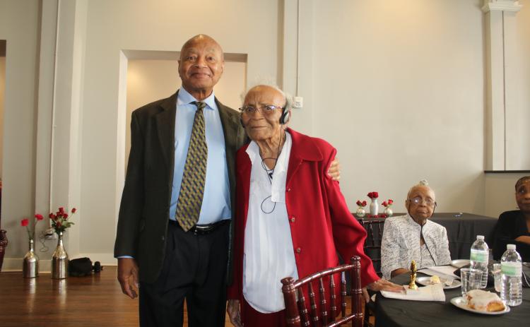 Merril Tunsil stands with his mother, retired educator Joyce Parnell Tunsil, who was recognized as being 95 years old at the Unsung Heroes program. Her sister Mildred Veronica Parnell Tunsil, (sitting background) was also recognized for being older than 90, as well as her brother Donal Parnell, who was siting at the table, for being 99 years old. (TONY BRITT/Lake City Reporter)