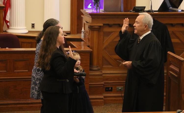 Circuit Court Judge David Fina (right) administers the oath of office to Suwannee County Judge Jennifer Kuyrkendall Griffin on Wednesday as Griffin’s daughter, Kendall, and mother look on. (MORGAN MCMULLEN/Lake City Reporter)
