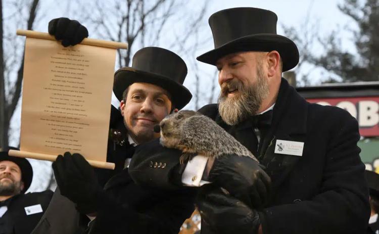 Groundhog Club handler A.J. Dereume holds Punxsutawney Phil, the weather prognosticating groundhog, while Vice President Dan McGinley reads the scroll during the 137th celebration of Groundhog Day on Gobbler’s Knob in Punxsutawney, Pa. (BARRY REEGER/Associated Press)