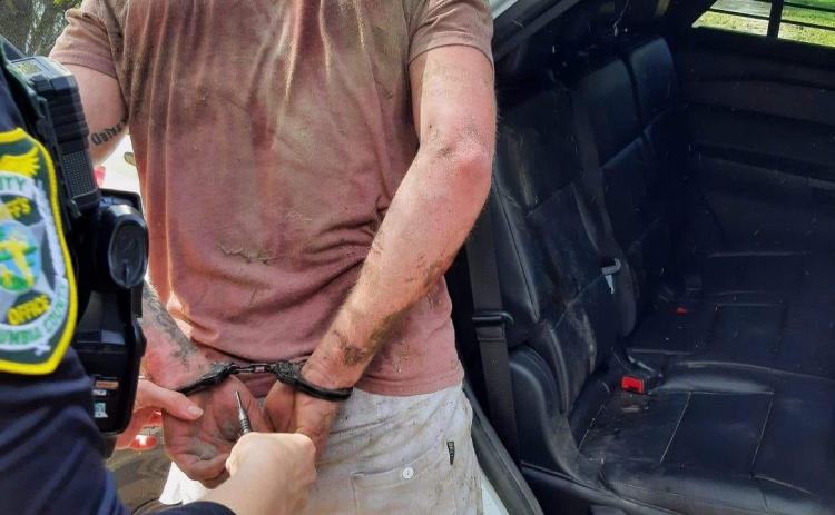 Brian Stalnaker is led away in handcuffs Wednesday after a day on the run from law enforcement. (COURTESY CCSO)