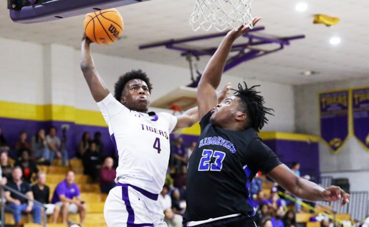Columbia forward Ty’jahn Wright flies for a dunk as Ridgeview forward Jairus Moore contests during Wednesday’s District 2-5A semifinal. (BRENT KUYKENDALL/Lake City Reporter)