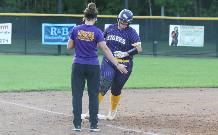 Columbia third baseman Alexis Blair high fives assistant coach Hayes Fulford as she rounds third base after one of her two home runs against Baker County on Monday night. (MORGAN MCMULLEN/Lake City Reporter)