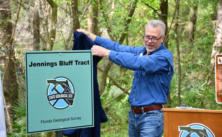 Harley Means, the state geologist and director of the Florida Geological Survey, unveils a new marker certifying the Jennings Bluff Tract as a State Geological Site on Friday. (COURTESY SRWMD)