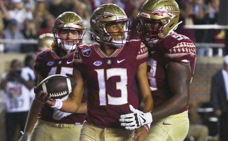 Florida State quarterback Jordan Travis (13) is congratulated by offensive lineman Maurice Smith (53) after scoring a touchdown against Florida on Nov. 25, 2022, in Tallahassee. (PHIL SEARS/Associated Press)