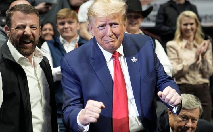 Former President Donald J. Trump gestures at the NCAA Wrestling Championships, Saturday, March 18, 2023, in Tulsa, Okla. (SUE OGROCKI/Associated Press)
