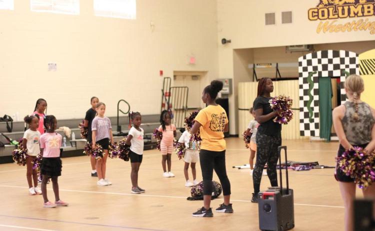Members of the Columbia High School color guard introduce girls to the activity during a clinic Saturday. (COURTESY)