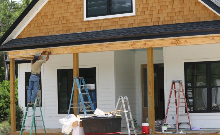 A worker with Stanley Crawford Construction works on the front of a house in the Hickory Cove neighborhood on Friday. The home will be part of the Parade of Homes this weekend. (JAMIE WACHTER/Lake City Reporter)