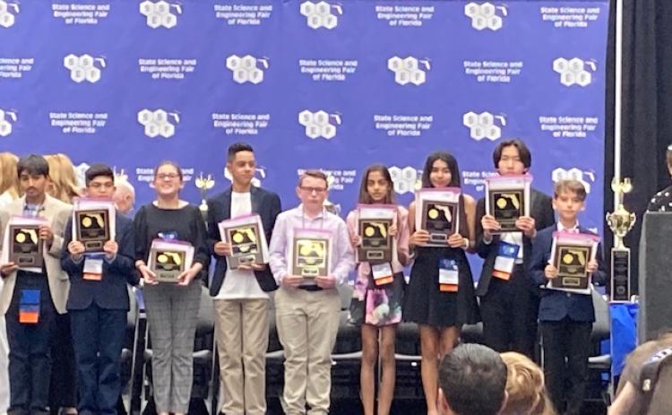 Fort White Middle School’s Cyler Robinson (center) receives his first-place recognition at the State Science and Engineering Fair of Florida in Lakeland on April 4-6. (COURTESY)