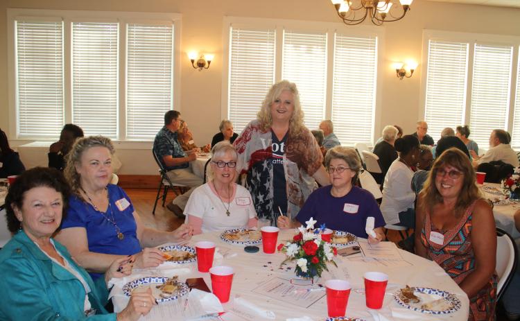 Columbia County Supervisor of Elections Tomi Brown (standing) makes the rounds at a dinner honoring election workers. (TONY BRITT/Lake City Reporter)