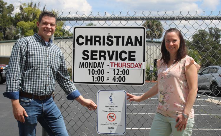 Chris Walters (left) and Brooke Frye show off the Christian Service Center’s new tobacco-free sign hanging in front of the center. (TONY BRITT/Lake City Reporter)