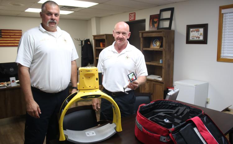 Columbia County Assistant Fire Chief Lance Hill (from left) and Fire Chief Jeff Crawford show off two new pieces of medical equipment, a Defib Tech Lifeline Arm unit, which is an automated compression devices for CPR and a video laryngoscope. CCFR also has a new brush truck that was put into service Friday. (TONY BRITT/Lake City Reporter)