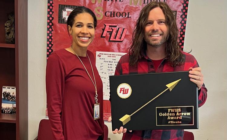 Nicole Bailey (from left), a Fort White High School assistant principal, presents Justin Jenkins, an eighth-grade science teacher, with the school’s inaugural Golden Arrow Award. The award is designed to recognize and honor any staff member that goes above and beyond their traditional job duties. (COURTESY)