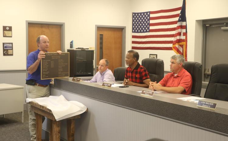 Will Rutherford with Clemons Rutherford & Associates presents the Lafayette County Commission with a plaque commemorating the Lafayette County Courthouse renovations. County Clerk Steve Land (second from left), Chairman Earnest Jones and Commissioner Lance Lamb look on. (MORGAN MCMULLEN/Lake City Reporter)