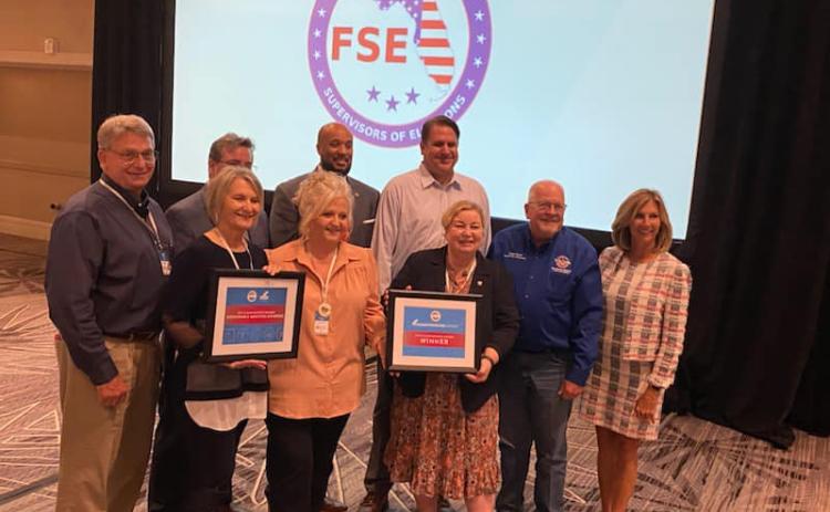 Columbia County Supervisor of Elections Tomi Brown (center) receives a U.S. Election Commission Clearinghouse Award for her office’s ‘Bubble it in’ T-shirt. (COURTESY)